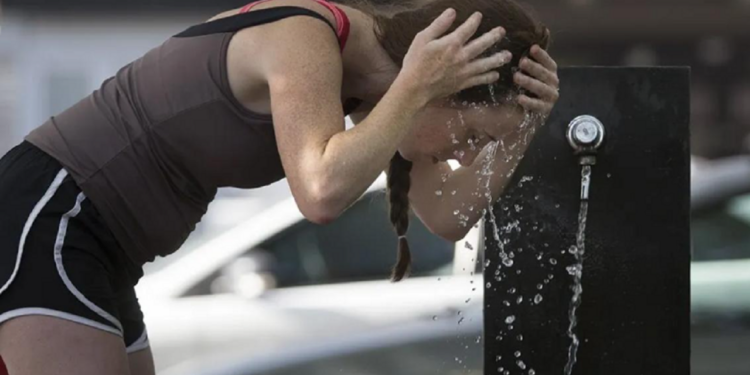 Un mujer se refresca en medio de la ola de calor que afecta al AMBA. /Télam.